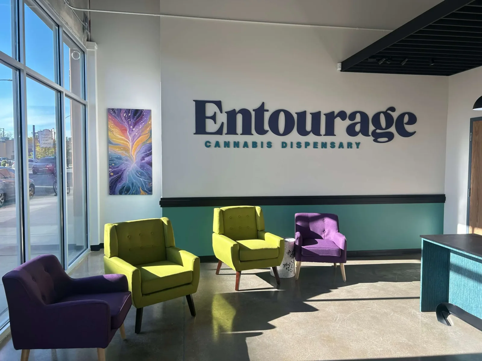 Entourage Dispensary reception area with green and purple chairs and the Entourage wall sign